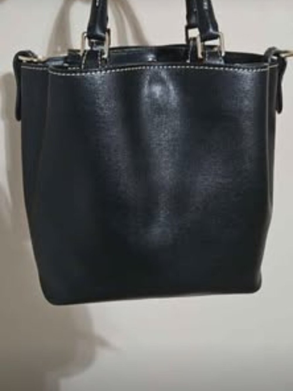 Sleek and classic Dooney & Bourke bucket tote crafted in durable, cross-hatched
